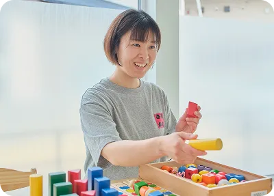 スタッフと子どもが玩具で遊ぶ様子